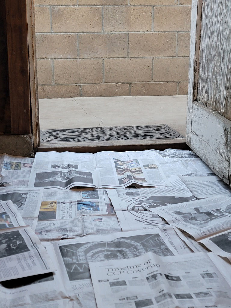 Garage floor with newspaper on floor leading outside